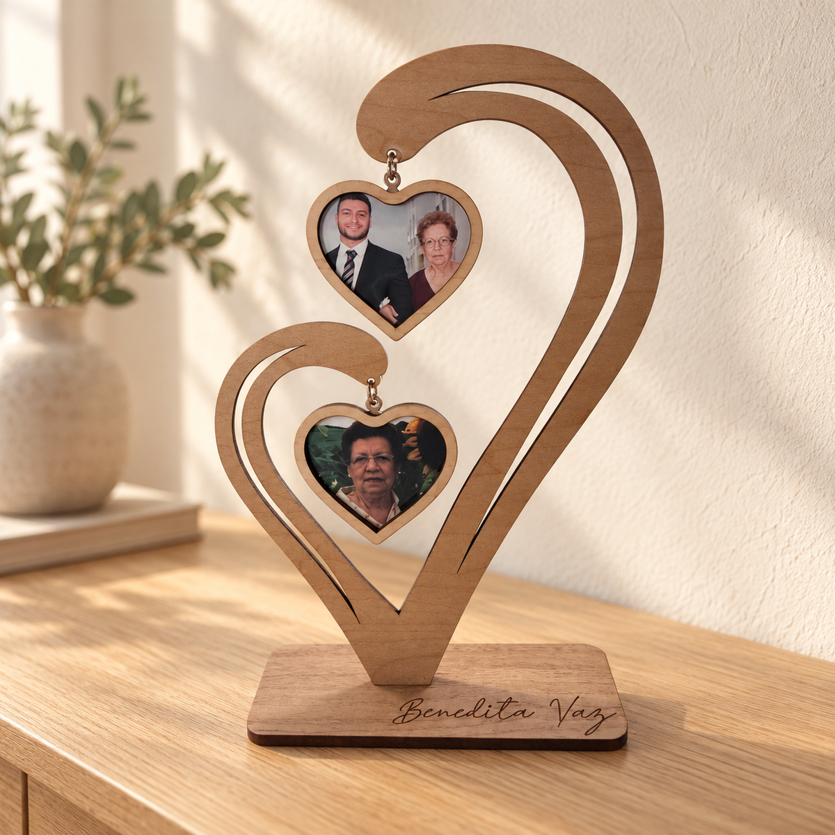 Freestanding wooden memorial photo heart with two family photos displayed on a console table