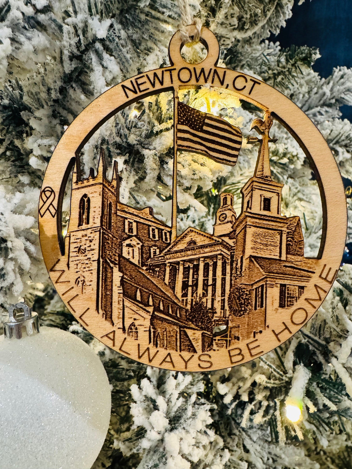 Newtown, CT Christmas ornament featuring an American flag, historic buildings, and a remembrance ribbon.